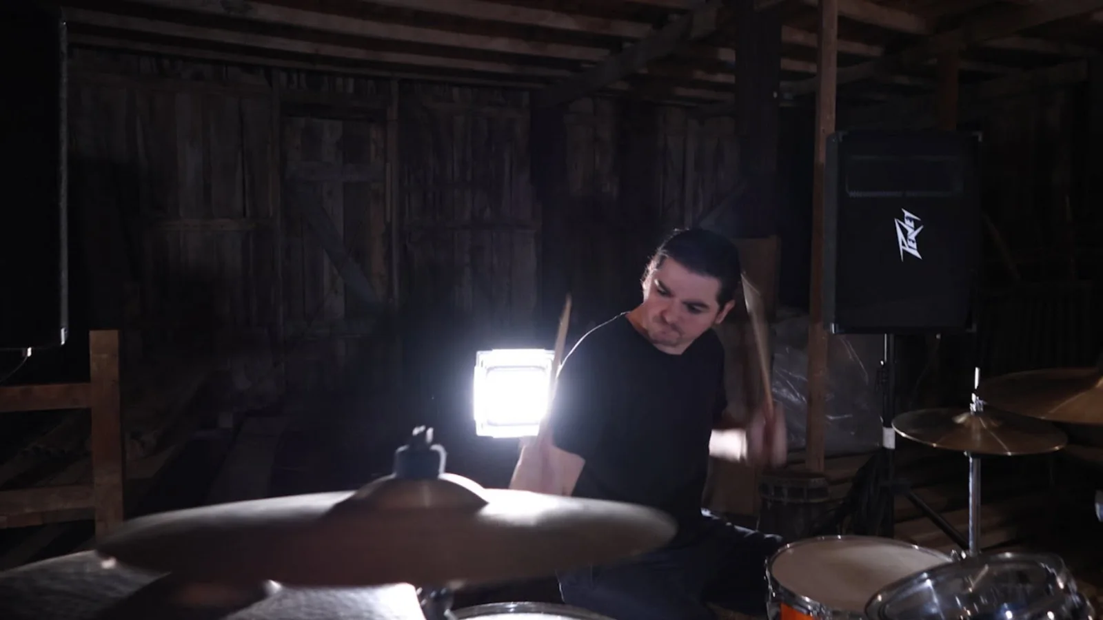 Idle Index drummer performing with bright backlighting